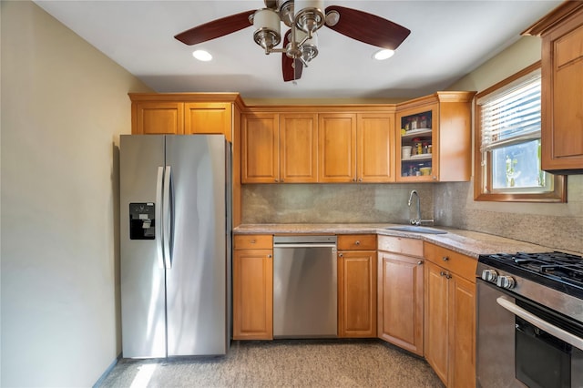 kitchen with stainless steel appliances, backsplash, sink, and ceiling fan