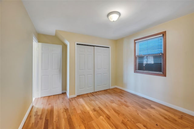 unfurnished bedroom with a closet and light hardwood / wood-style flooring