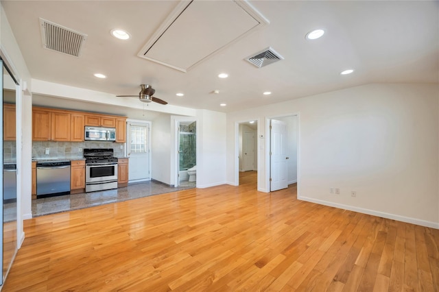 kitchen featuring appliances with stainless steel finishes, ceiling fan, light wood-type flooring, and tasteful backsplash