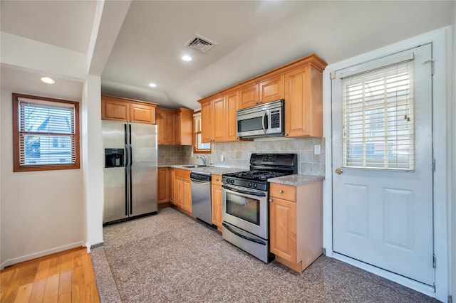 kitchen featuring sink, stainless steel appliances, plenty of natural light, and decorative backsplash