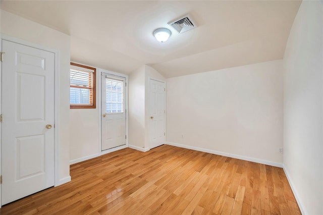 additional living space with vaulted ceiling and light hardwood / wood-style flooring