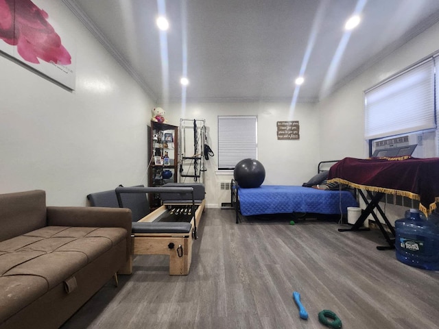 bedroom with hardwood / wood-style floors, cooling unit, radiator, and ornamental molding