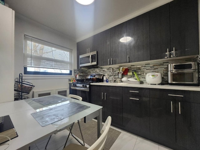 kitchen with backsplash, crown molding, light tile patterned floors, and stainless steel appliances