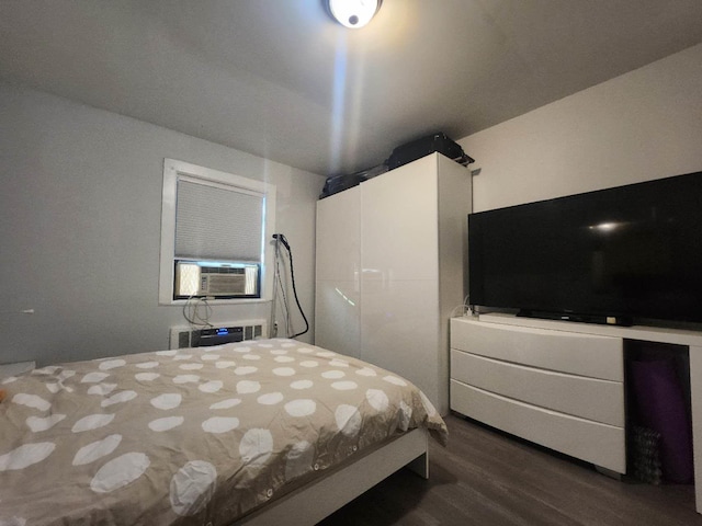 bedroom featuring dark hardwood / wood-style floors, cooling unit, and an AC wall unit