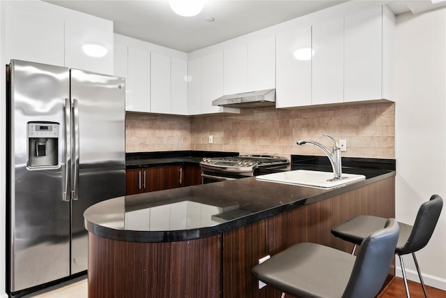 kitchen featuring exhaust hood, sink, white cabinetry, kitchen peninsula, and stainless steel appliances