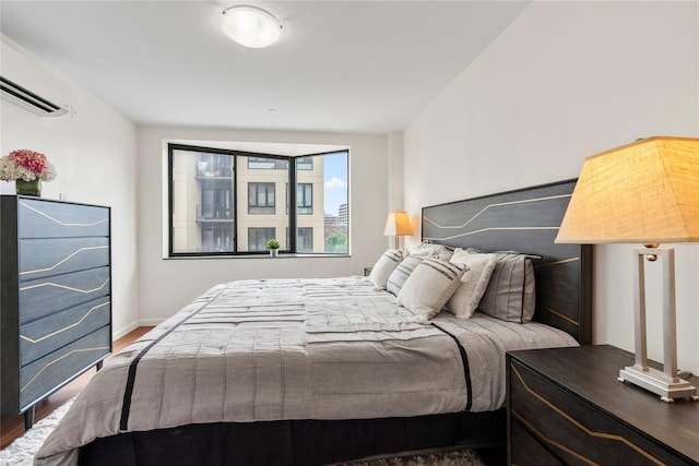 bedroom featuring hardwood / wood-style floors and a wall mounted AC