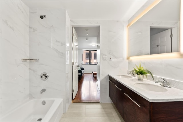 bathroom featuring tile patterned flooring, vanity, and tiled shower / bath