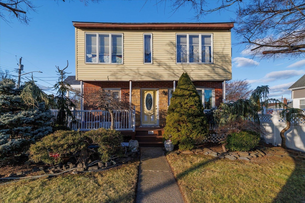 view of front of house with a front yard and covered porch