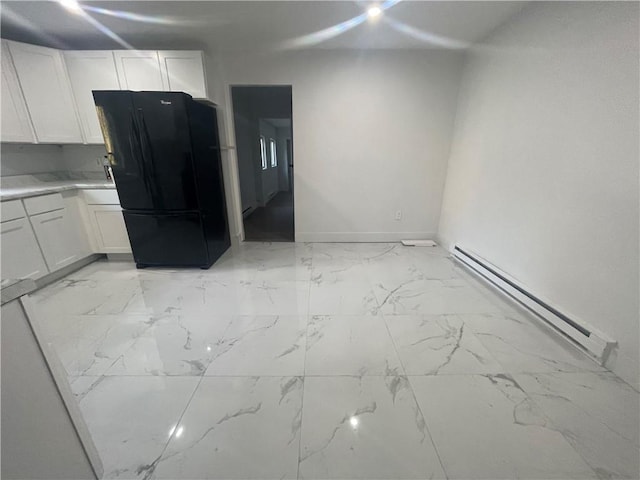 kitchen with white cabinets, a baseboard radiator, and black fridge