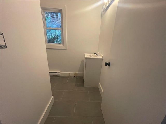 interior space featuring sink, dark tile patterned flooring, and a baseboard heating unit