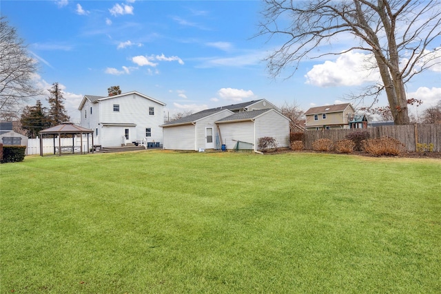 rear view of property featuring a gazebo and a yard