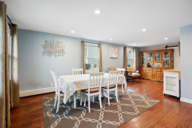 dining room with dark wood-type flooring and a baseboard heating unit