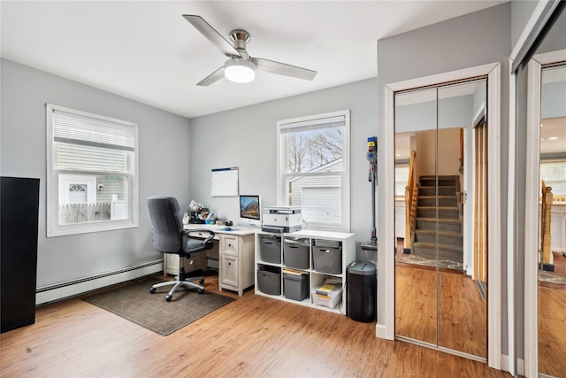 office featuring a baseboard heating unit, ceiling fan, and light wood-type flooring