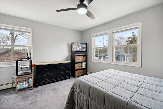 carpeted bedroom with a baseboard heating unit, ceiling fan, and multiple windows