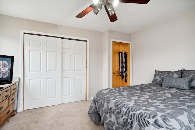 bedroom featuring ceiling fan, light colored carpet, and a closet