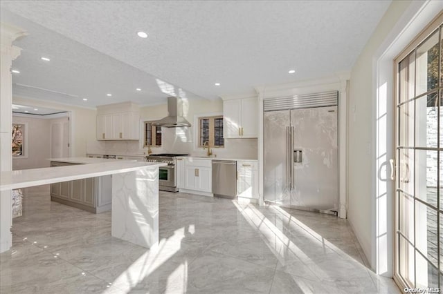 kitchen featuring island exhaust hood, sink, high quality appliances, a center island, and white cabinetry