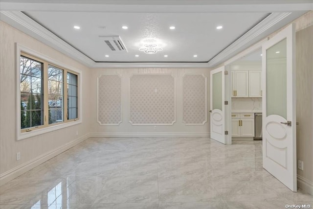 empty room with a tray ceiling and ornamental molding