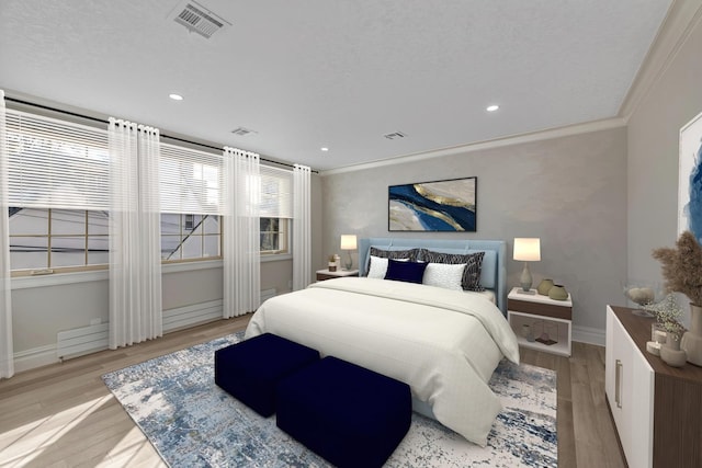 bedroom with ornamental molding and light wood-type flooring