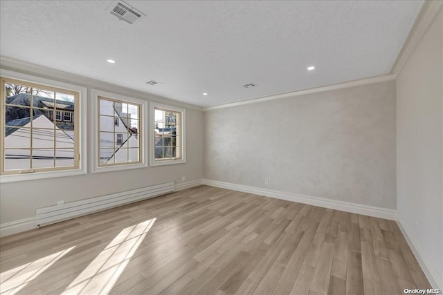 empty room featuring light hardwood / wood-style floors, ornamental molding, and a baseboard heating unit