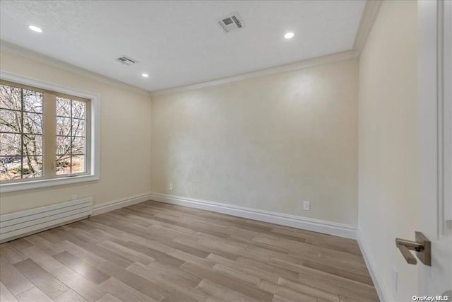 spare room with light hardwood / wood-style floors, baseboard heating, and ornamental molding