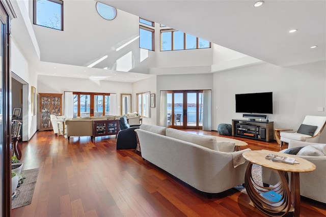 living room with french doors, dark hardwood / wood-style flooring, and a high ceiling