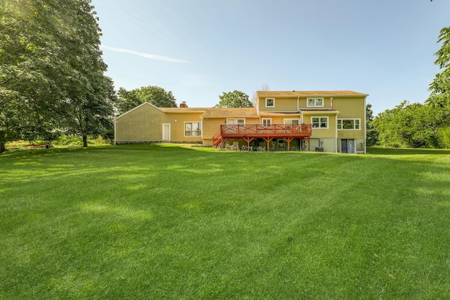 rear view of property featuring a yard and a wooden deck