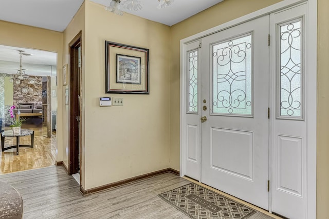 entrance foyer with a notable chandelier, plenty of natural light, and light wood-type flooring