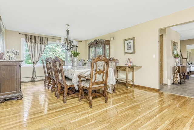 dining area with a baseboard heating unit, light hardwood / wood-style floors, and a notable chandelier