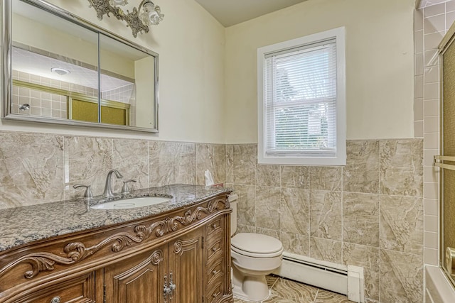 bathroom featuring toilet, vanity, tile walls, and a baseboard heating unit