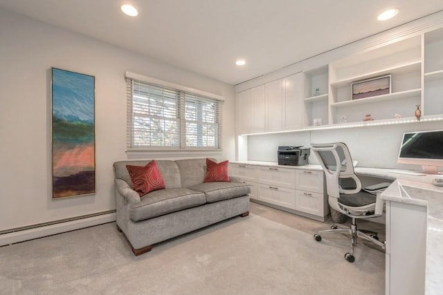 office featuring a baseboard heating unit, built in desk, and light colored carpet