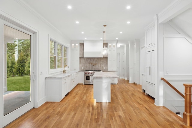 kitchen featuring white cabinetry, double oven range, decorative light fixtures, and a center island