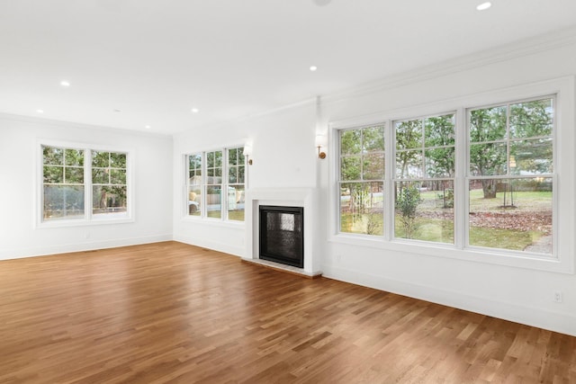 unfurnished living room featuring ornamental molding and wood-type flooring