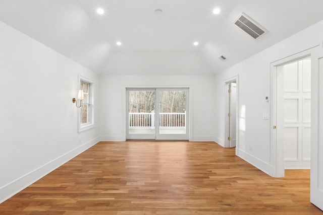 empty room with lofted ceiling and light hardwood / wood-style flooring