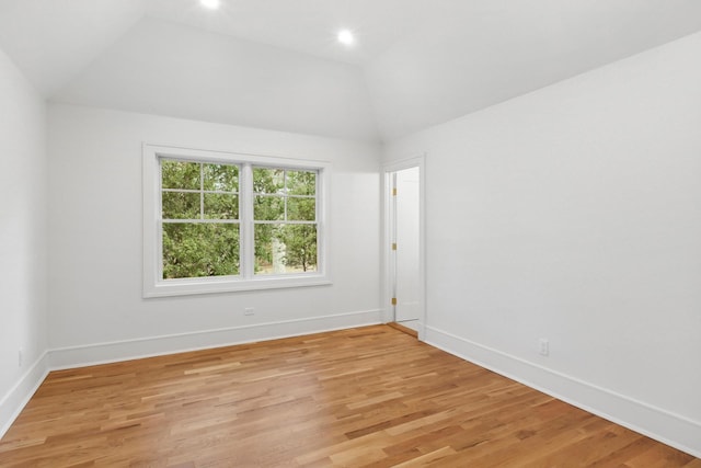 empty room with lofted ceiling and light hardwood / wood-style flooring