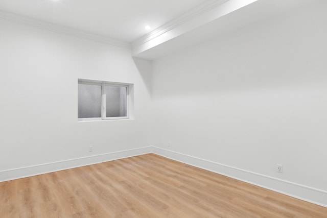 empty room with ornamental molding and light hardwood / wood-style floors