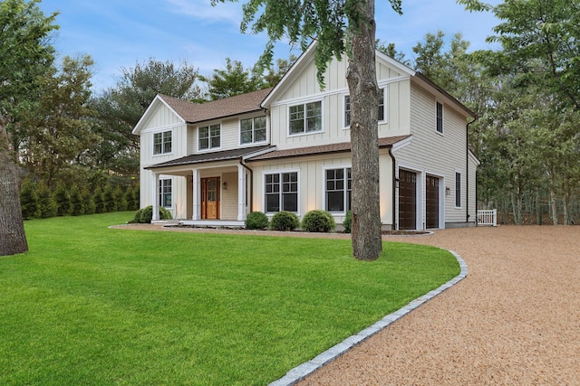 view of front of property with a garage, a front yard, and covered porch