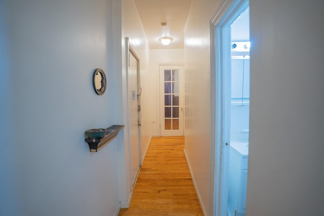 hallway with light wood-style floors and baseboards