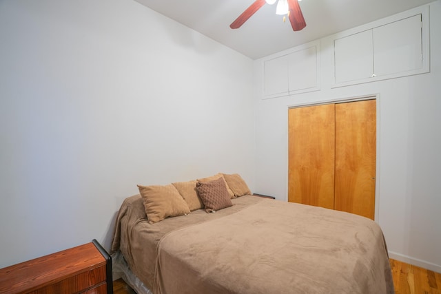 bedroom with ceiling fan, a closet, and hardwood / wood-style floors