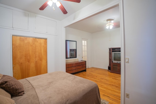 bedroom with ceiling fan, a closet, and light hardwood / wood-style floors