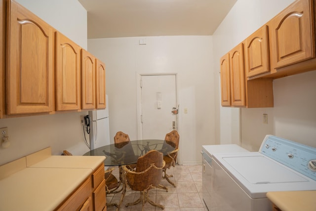 washroom with light tile patterned floors, independent washer and dryer, and cabinets