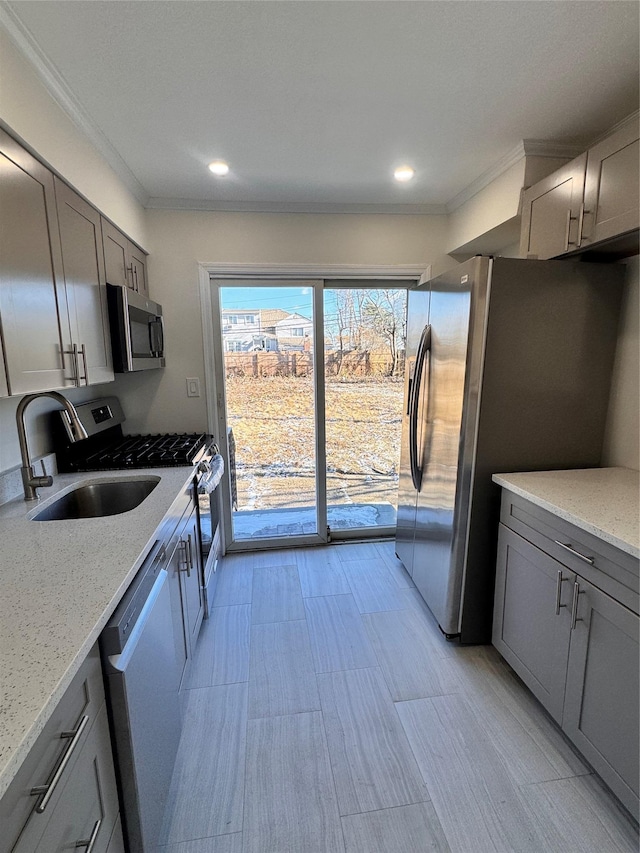 kitchen with crown molding, light stone counters, sink, and appliances with stainless steel finishes