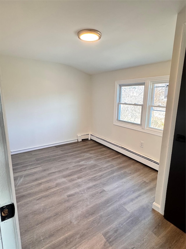 spare room featuring a baseboard radiator and hardwood / wood-style flooring