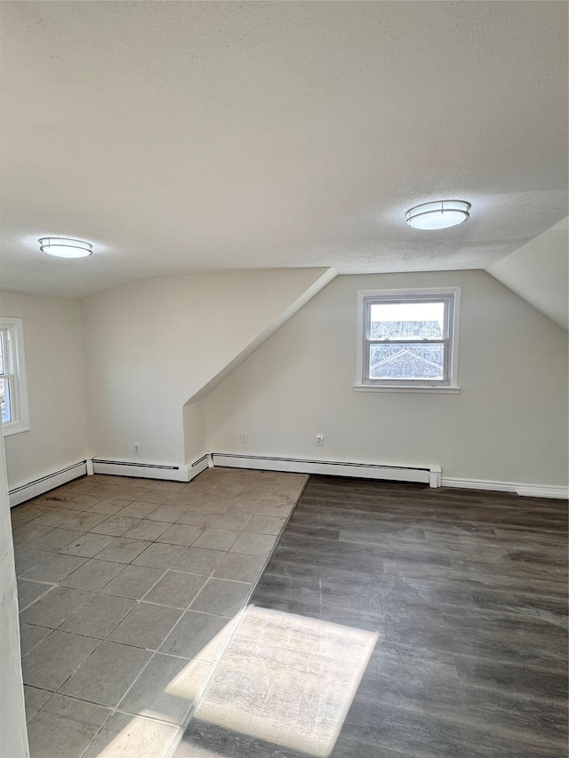 bonus room featuring a textured ceiling, a baseboard radiator, and vaulted ceiling