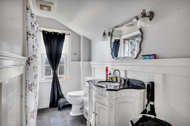 24 Wagner St, Call Listing Agent, NY 13339 - full bath with lofted ceiling, toilet, vanity, a wainscoted wall, and tile patterned flooring