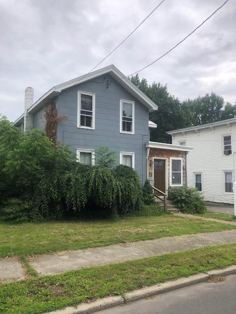 24 Wagner St, Call Listing Agent, NY 13339 - view of front facade with a front lawn and a chimney