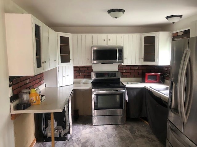24 Wagner St, Call Listing Agent, NY 13339 - kitchen with appliances with stainless steel finishes, light countertops, white cabinetry, tasteful backsplash, and glass insert cabinets