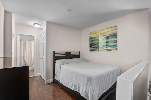 bedroom with dark hardwood / wood-style floors and a closet