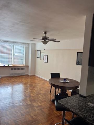 dining room with ceiling fan, radiator heating unit, and parquet flooring