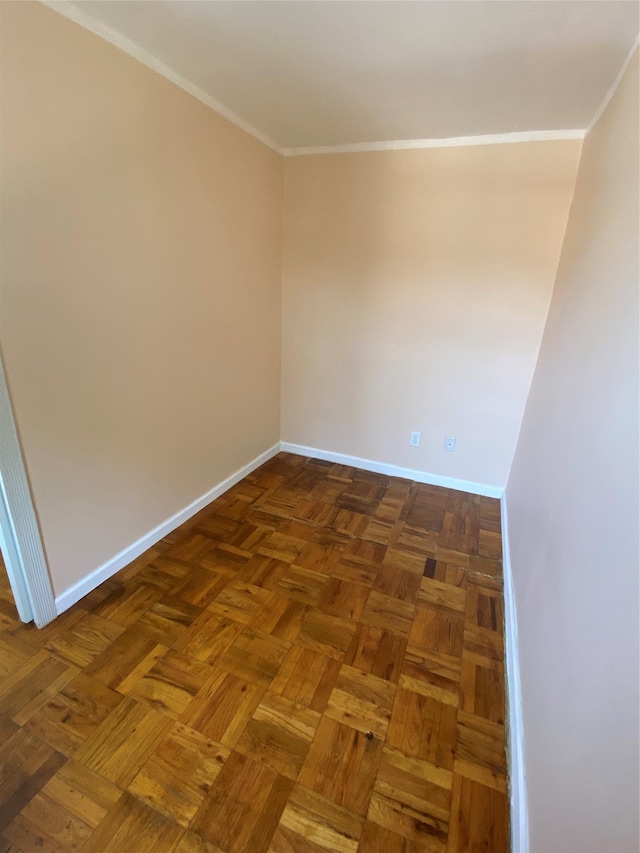 unfurnished room featuring dark parquet flooring and ornamental molding