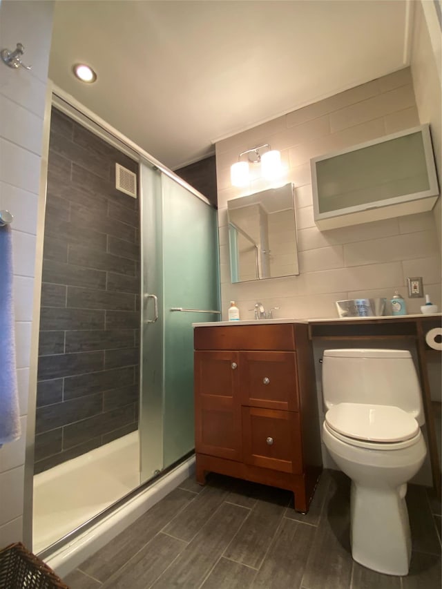 bathroom featuring vanity, toilet, and walk in shower